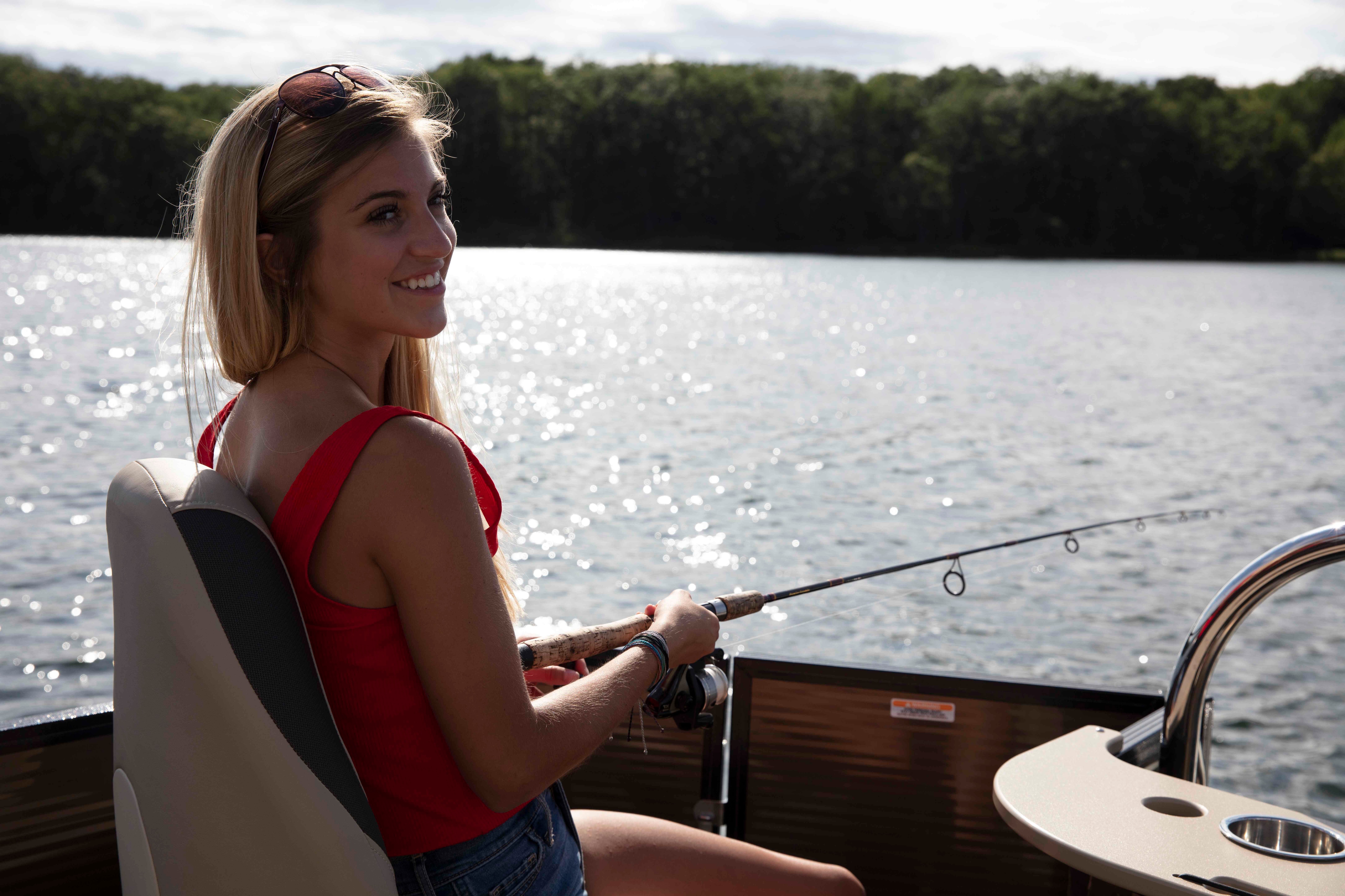 Woman fishing on a Manitou Encore Pro Angler Pontoon Boat