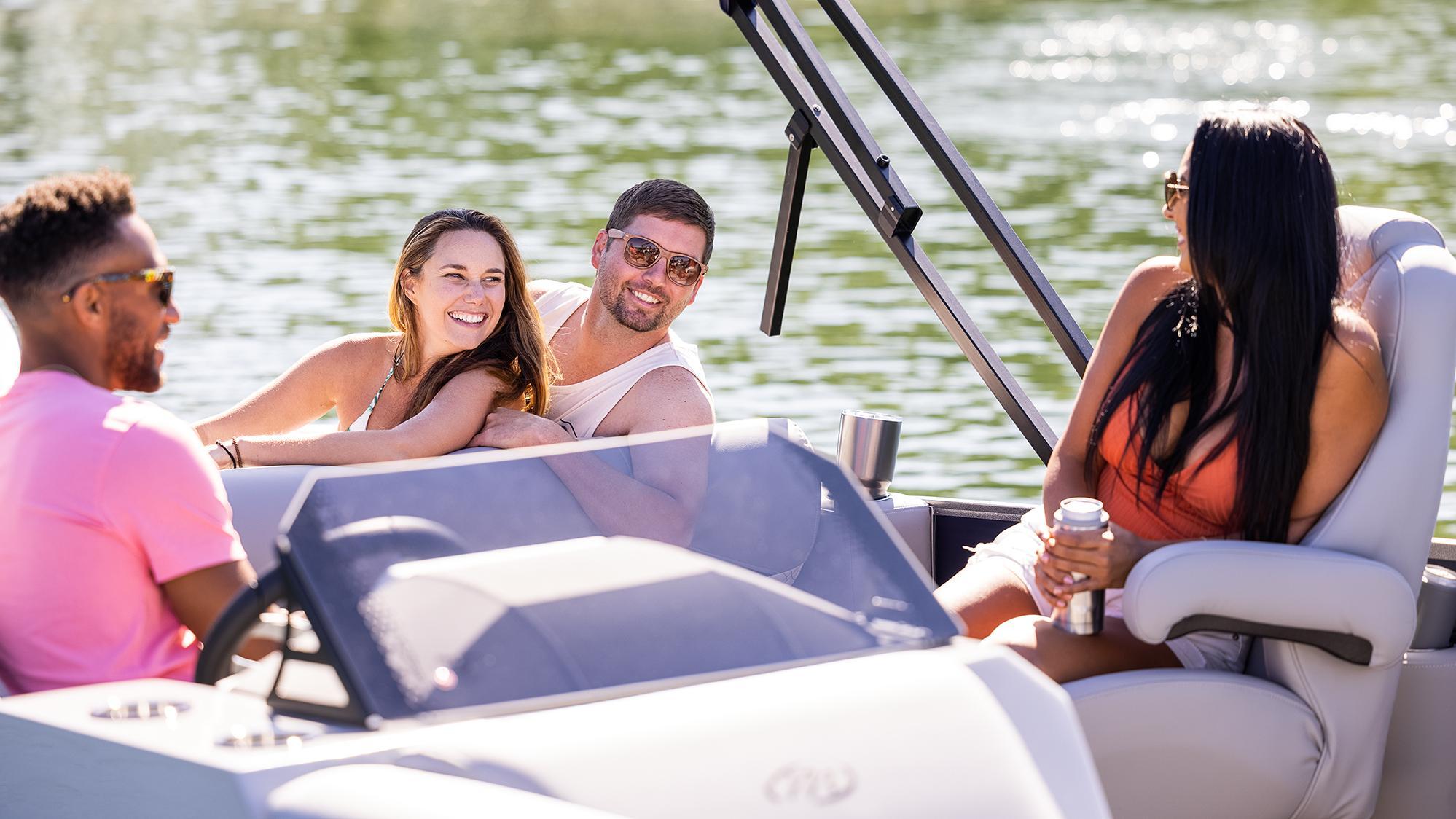 4 friends relaxing under the sun on a Manitou Pontoon