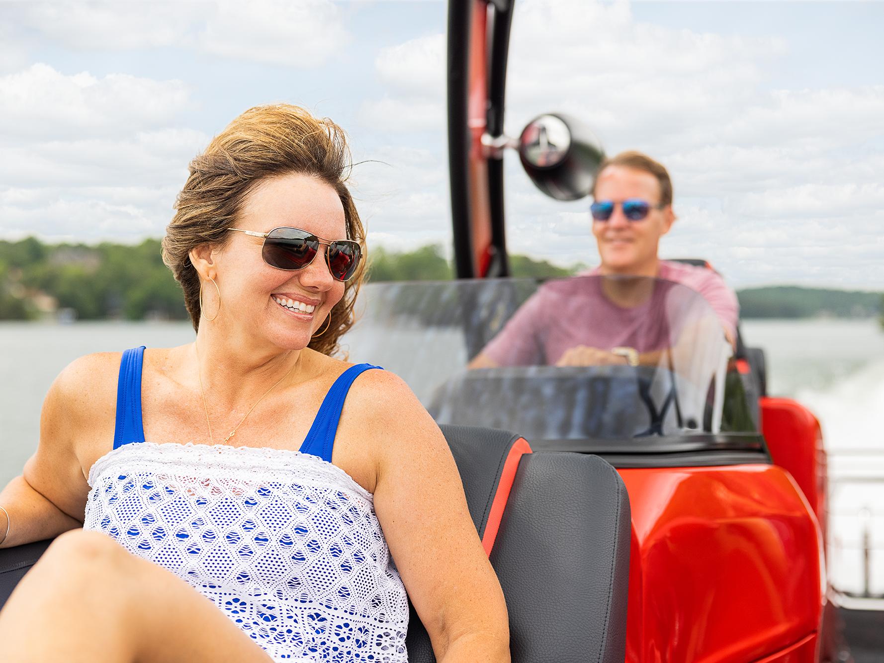 Couple en croisière dans un bateau ponton rouge Manitou Luxury XT