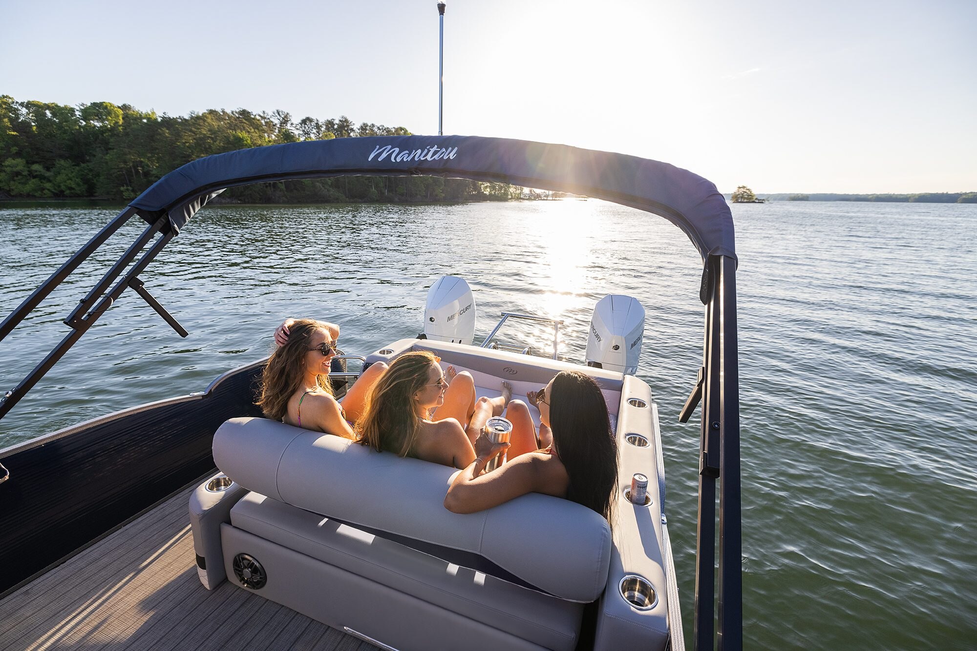 Femmes se prélassant sur un bateau ponton Manitou Encore