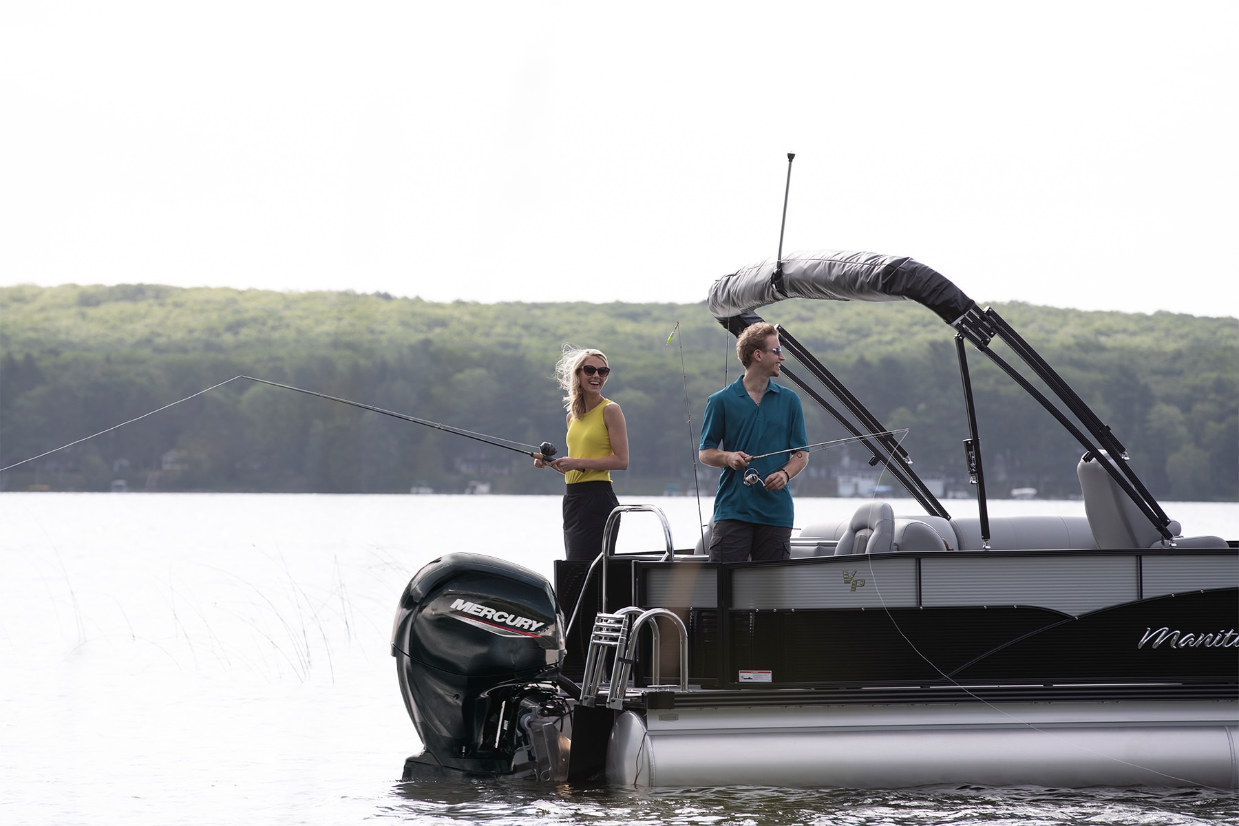 Couple fishing on a Manitou Oasis Angler Pontoon Boat