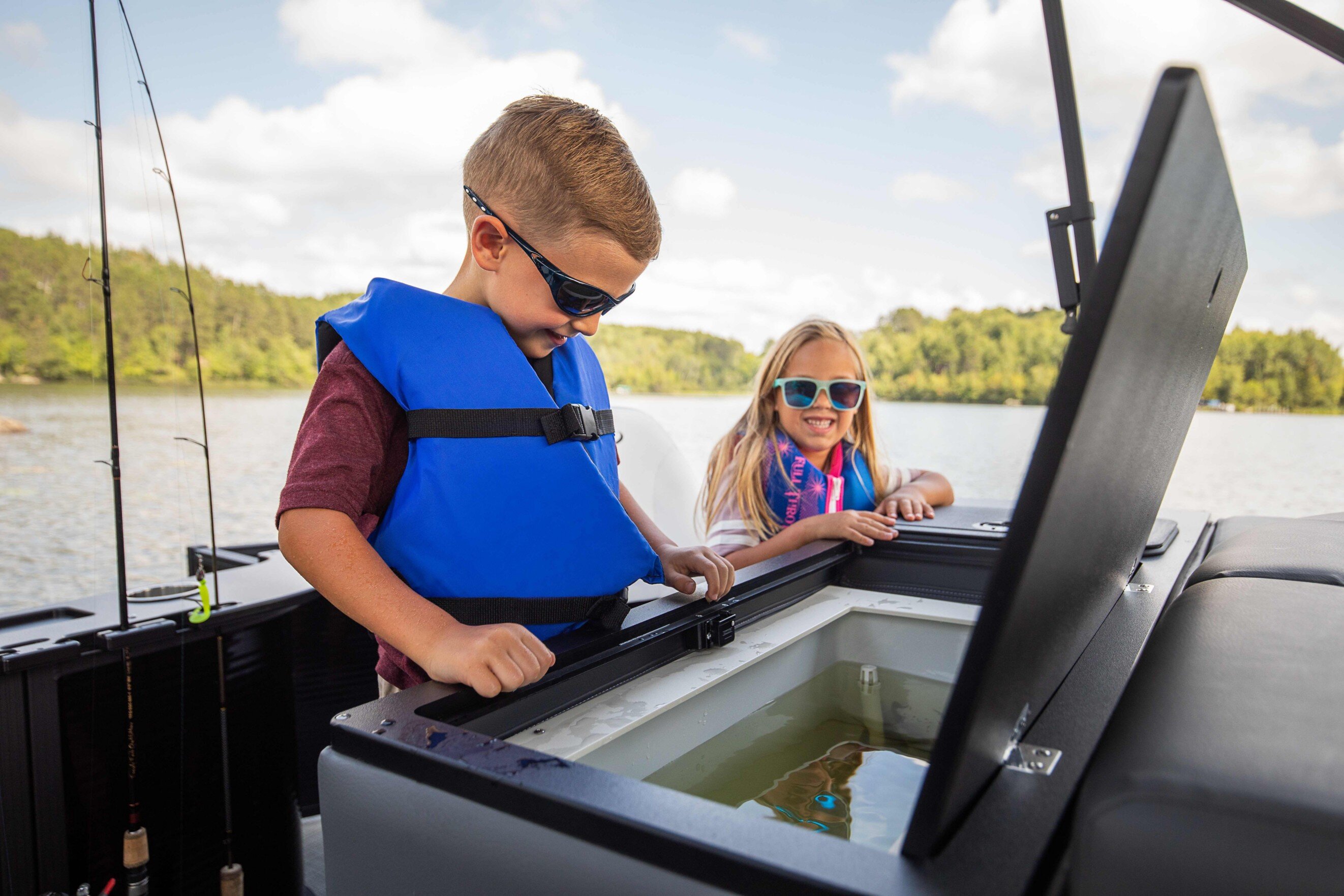 Garçon utilisant le vivier de pêche du bateau ponton Manitou