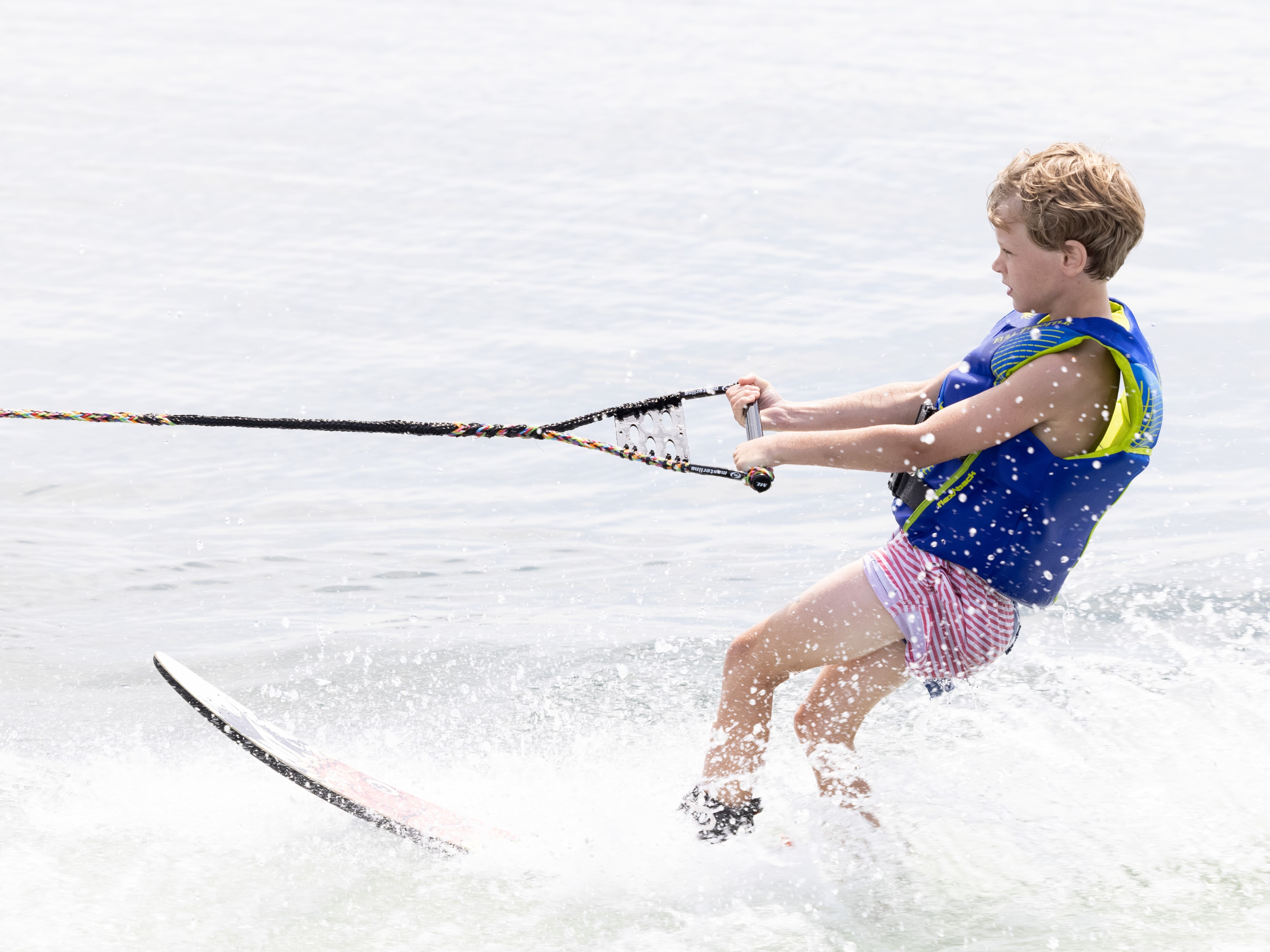 Manitou Pontoon Boat pulling a kid for a water skiing ride