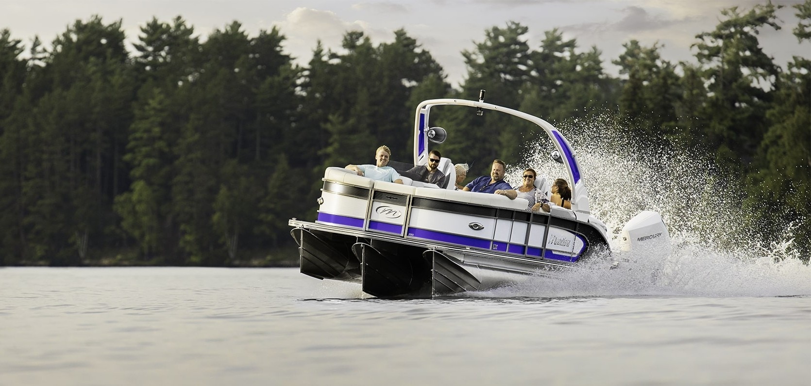 Manitou LX Pontoon Boat cruising fast on a lake