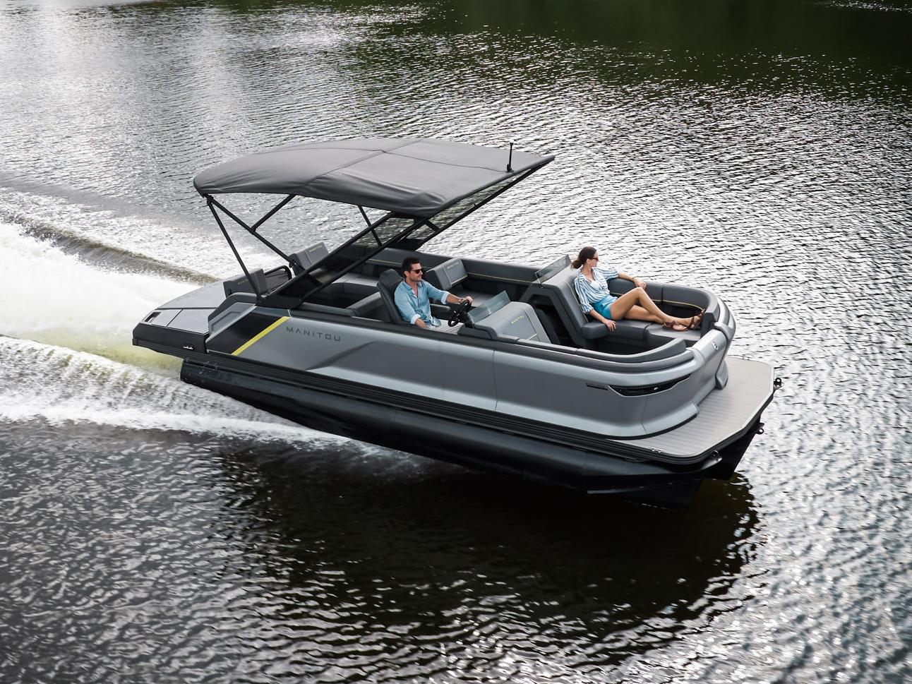 2023 Manitou Explore pontoon boat speeding on a lake