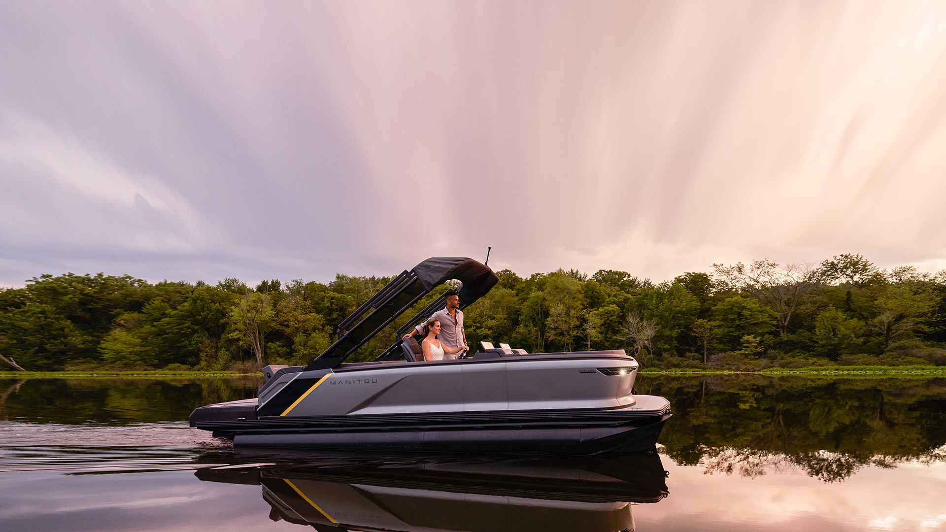 Couple enjoying a slow 2023 Manitou Explore ride while watching the sunset