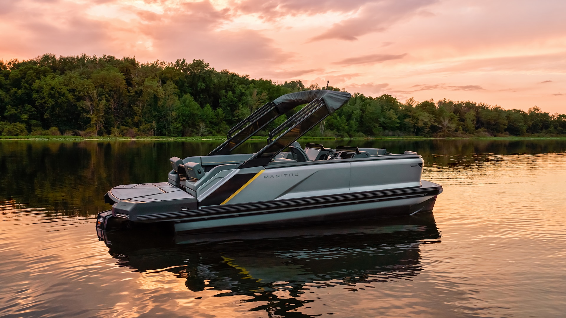 Manitou Explore 2023 pontoon in the middle of a lake during a sunset