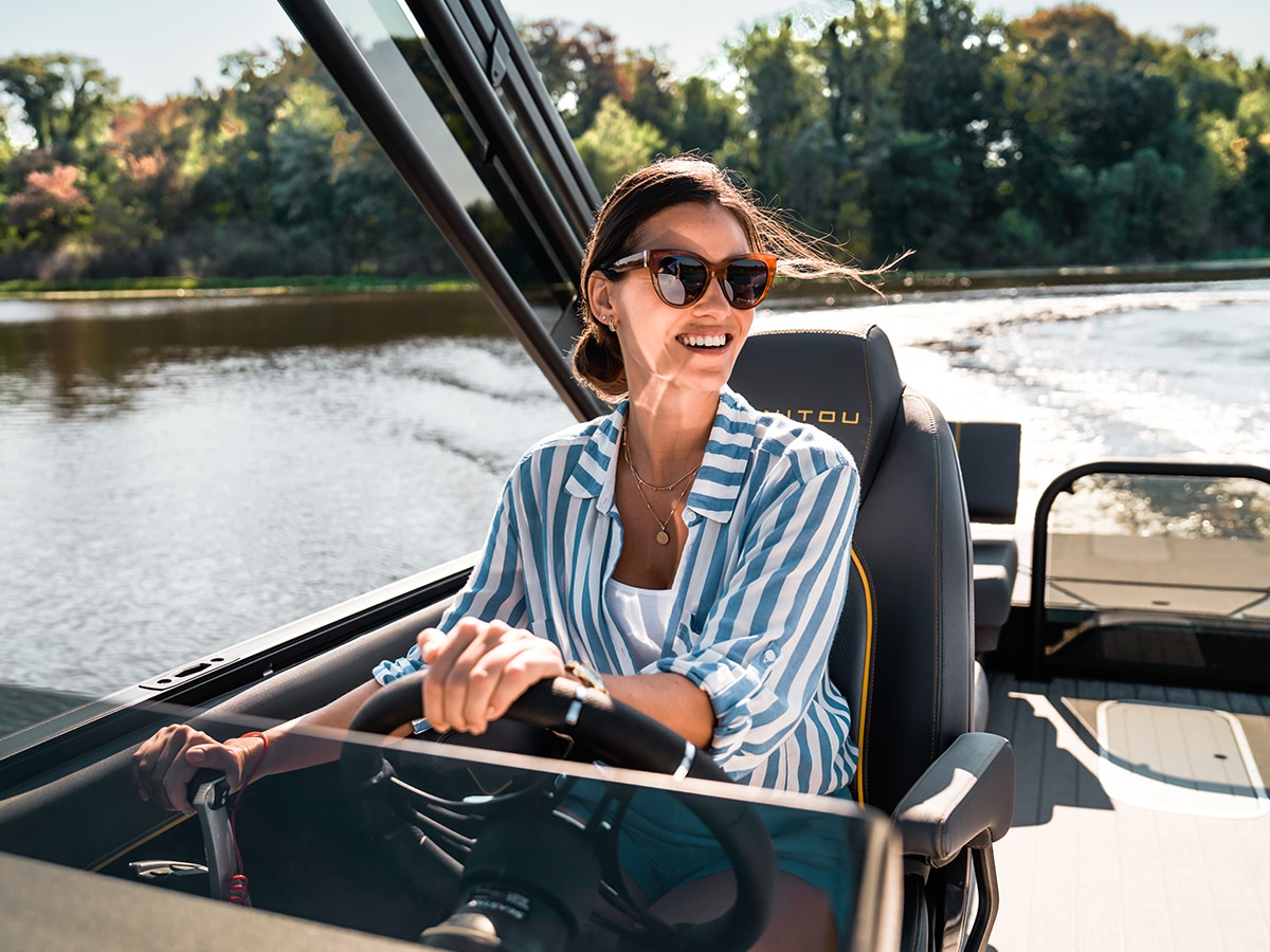 Femme pilotant un ponton Manitou Explore 2023