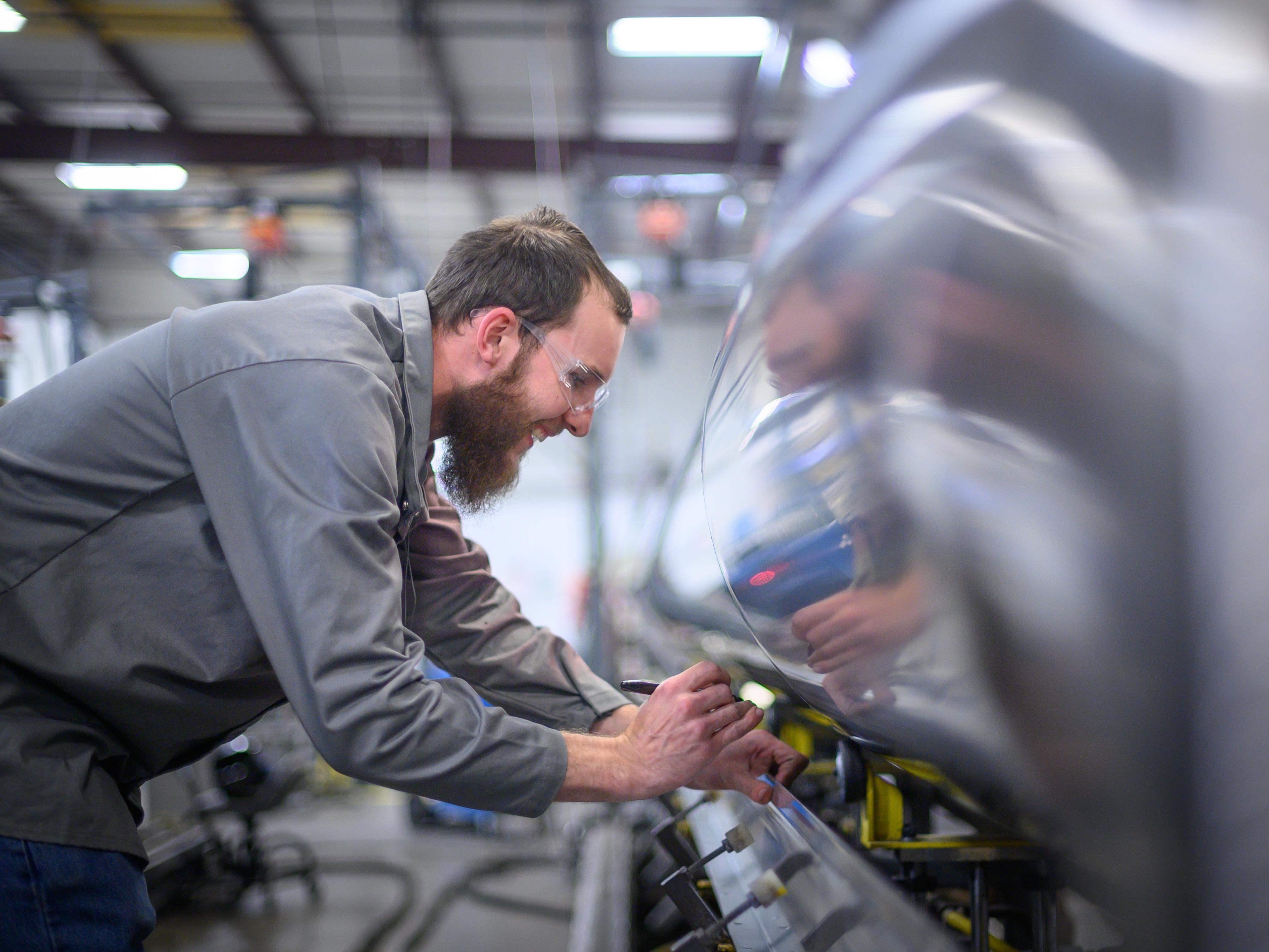 Employé qui travaille sur un nouveau ponton Manitou à l'usine de fabrication à Lansing, MI