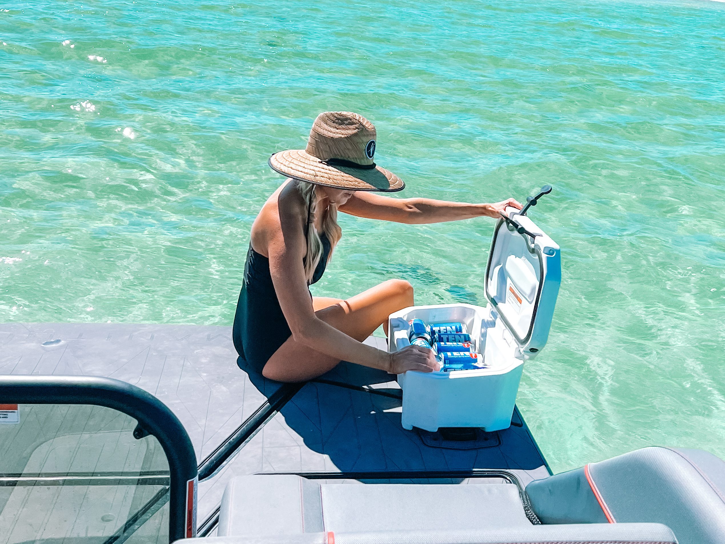 Jenny Reimold taking full advantage of her Explore pontoon's Max Deck while grabbing something from a LinQ cooler