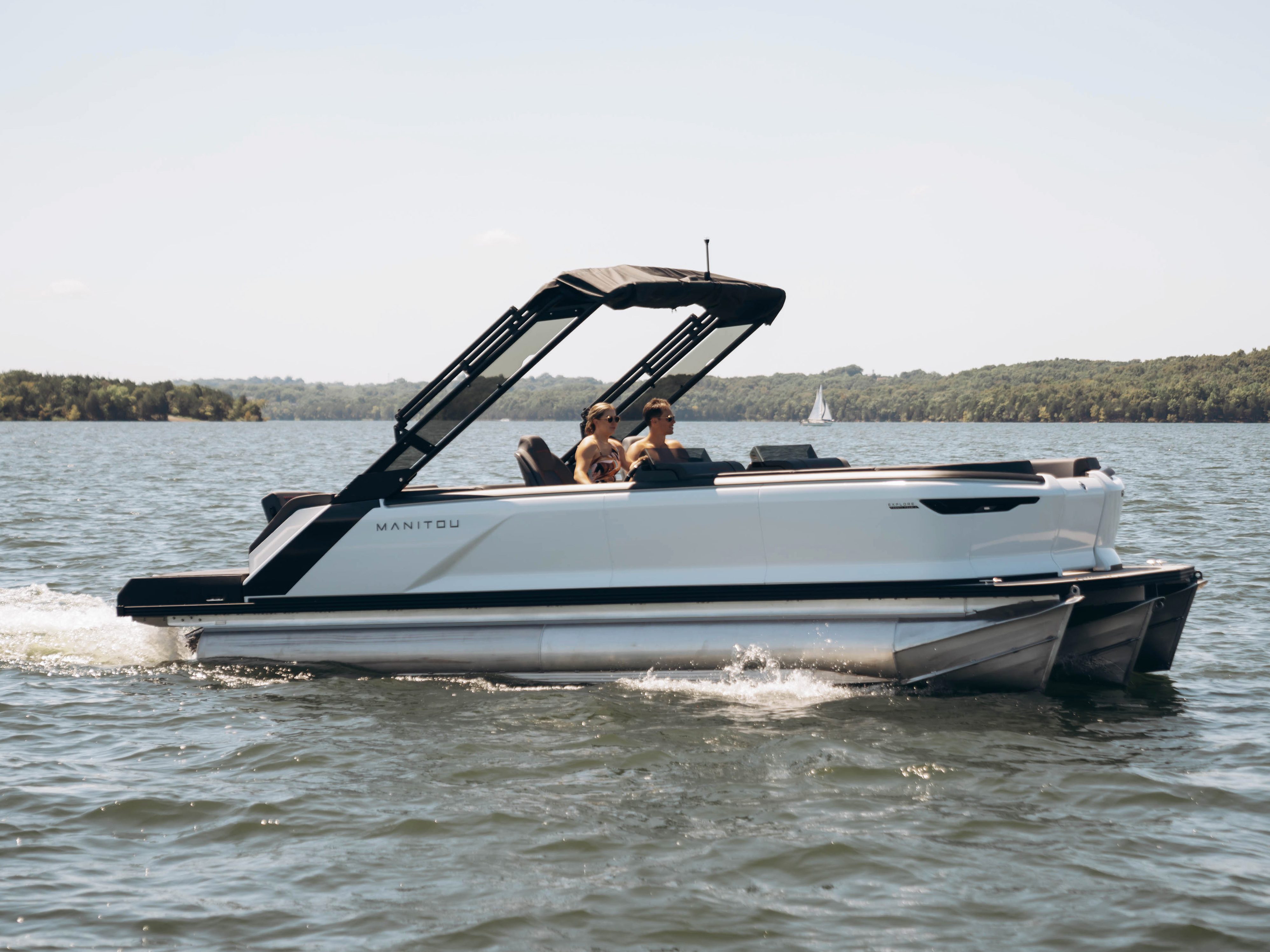 Manitou Pontoon Boat riding on a lake