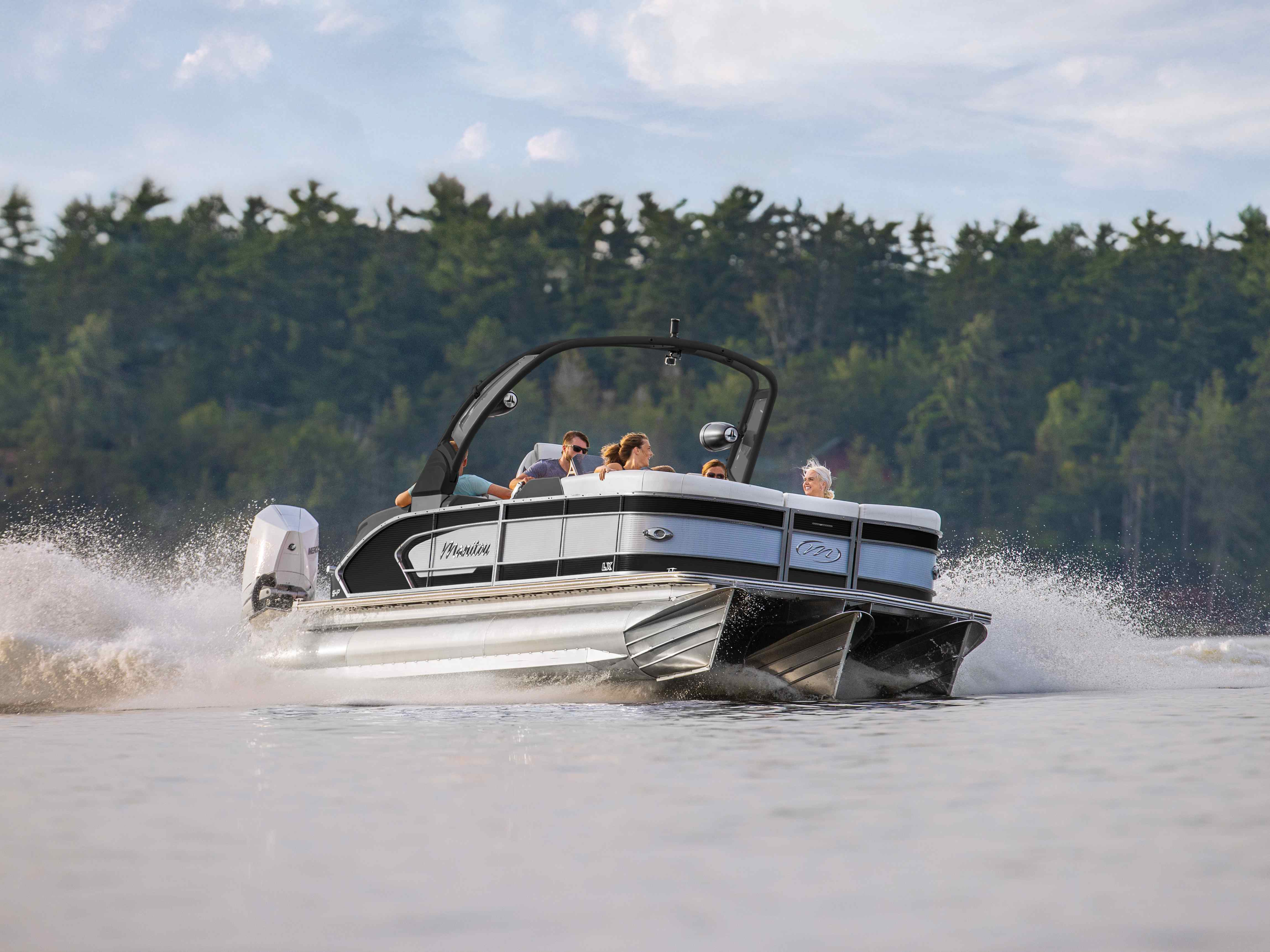 Family riding on a 2023 Manitou LX pontoon boat