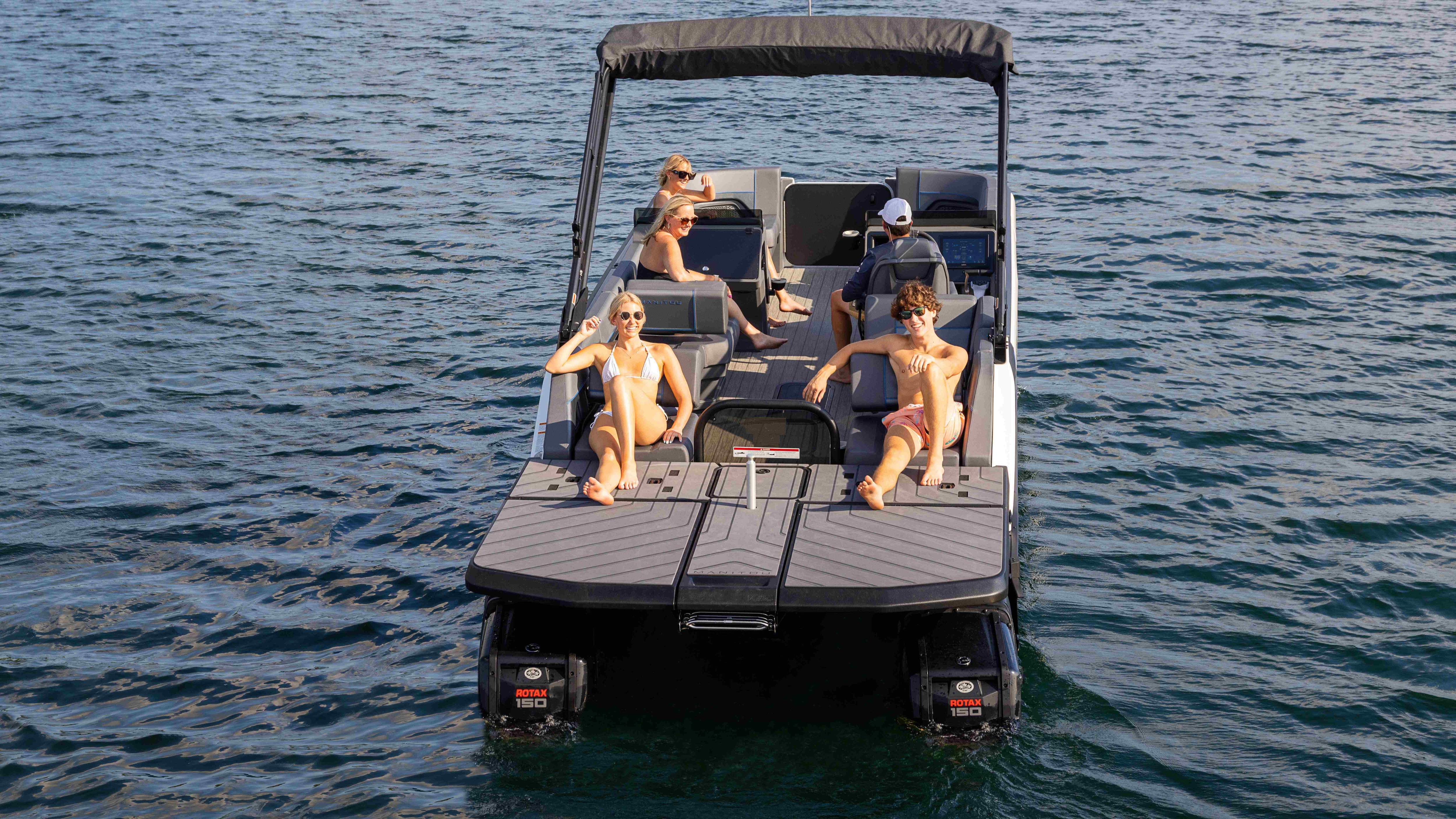 Group of friends relaxing on an idle Manitou Explore pontoon