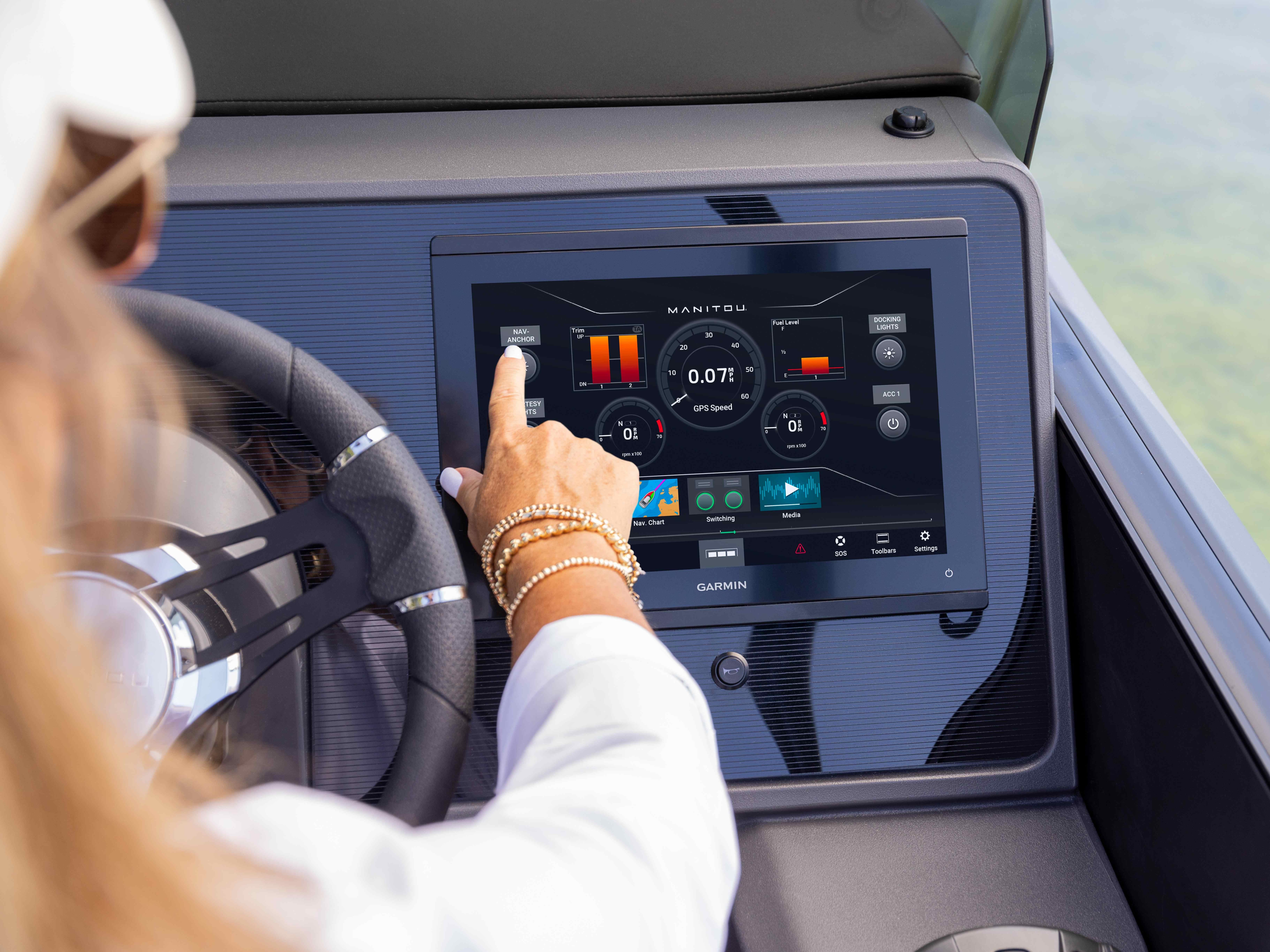 Woman using the 2024 Manitou Explore Switchback pontoon's touchscreen display